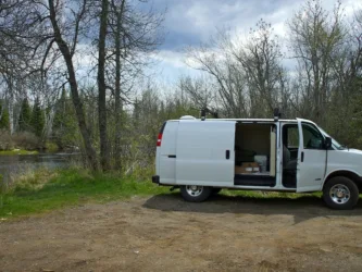converted rv van by a river