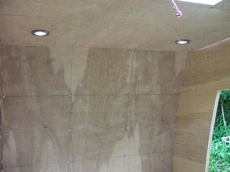 recessed lighting and spaced out screws attach the luan plywood