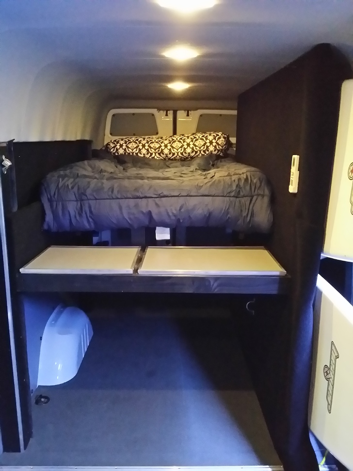The elevated bed in this van camper makes it easy to store all of your toys