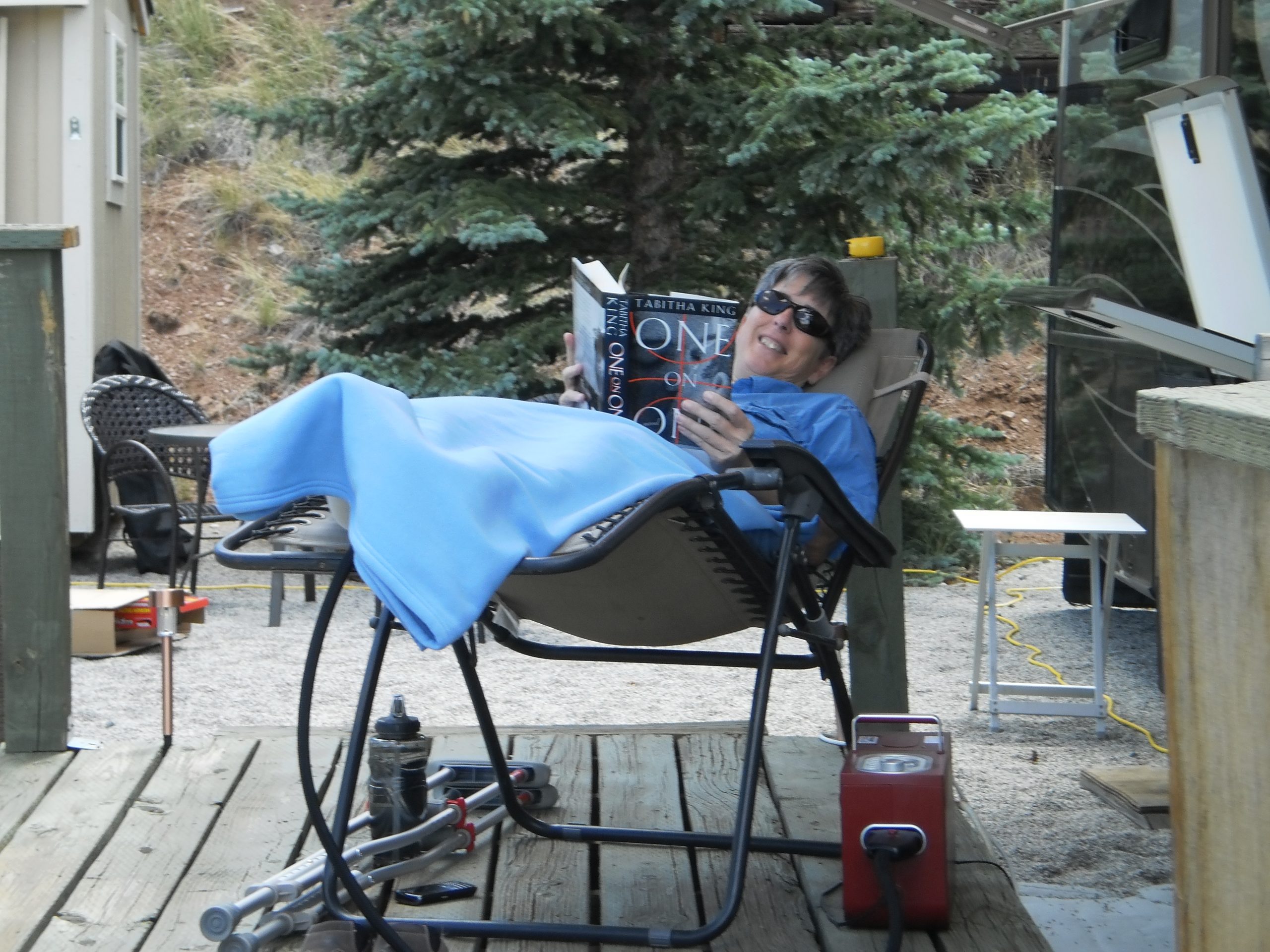 RVer recovering from knee surgery in a recliner, outside next to a motorhome.