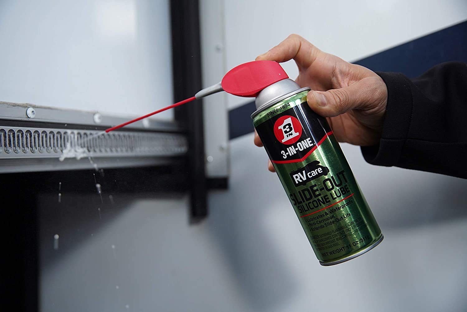 RV slideout lubricant being sprayed onto gear on the side of a slideout - RV slide-outs