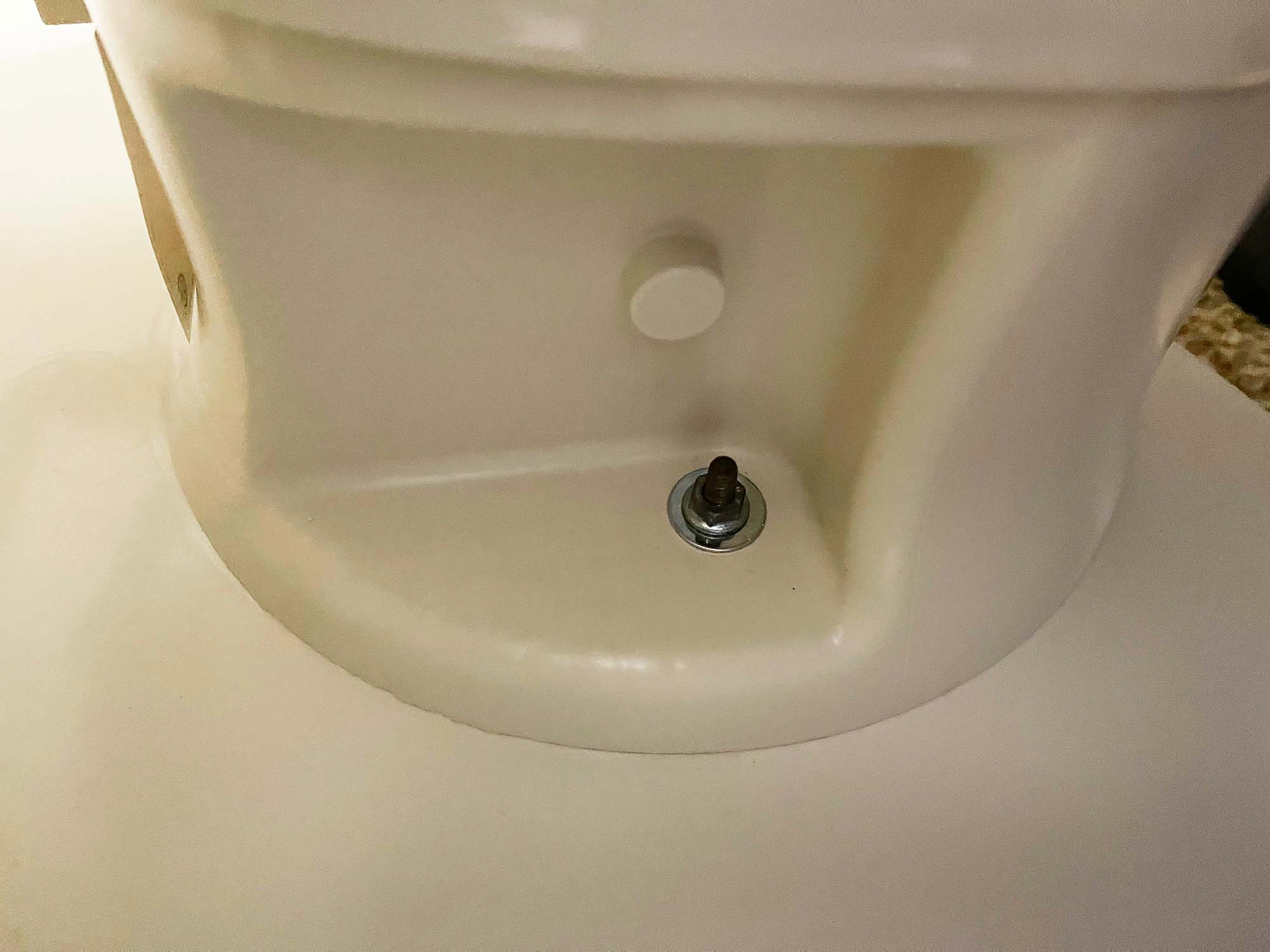 bolt and nut that attach a toilet to the mounting ring 