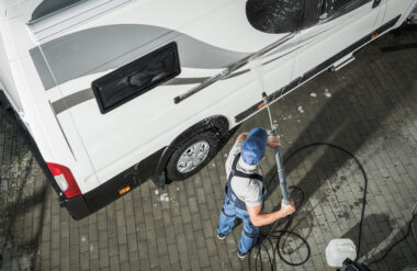 man pressure washing an RV - how to remove RV decals