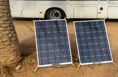 Two solar panels set up on the ground beside a motorhome - how many solar panels do I need for my RV?