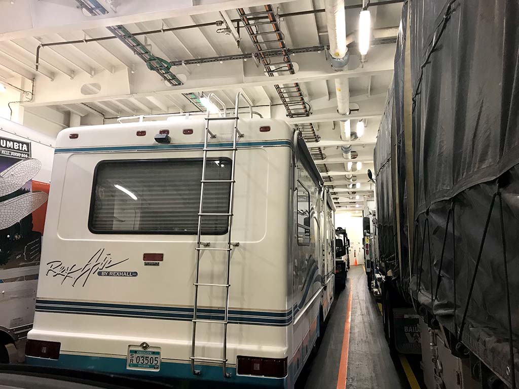 An RV parked on the truck deck of a ferry.
