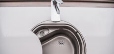 RV faucet closeup - feature photo for How To Clean An RV Fresh Water Tank