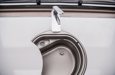 RV faucet closeup - feature photo for How To Clean An RV Fresh Water Tank