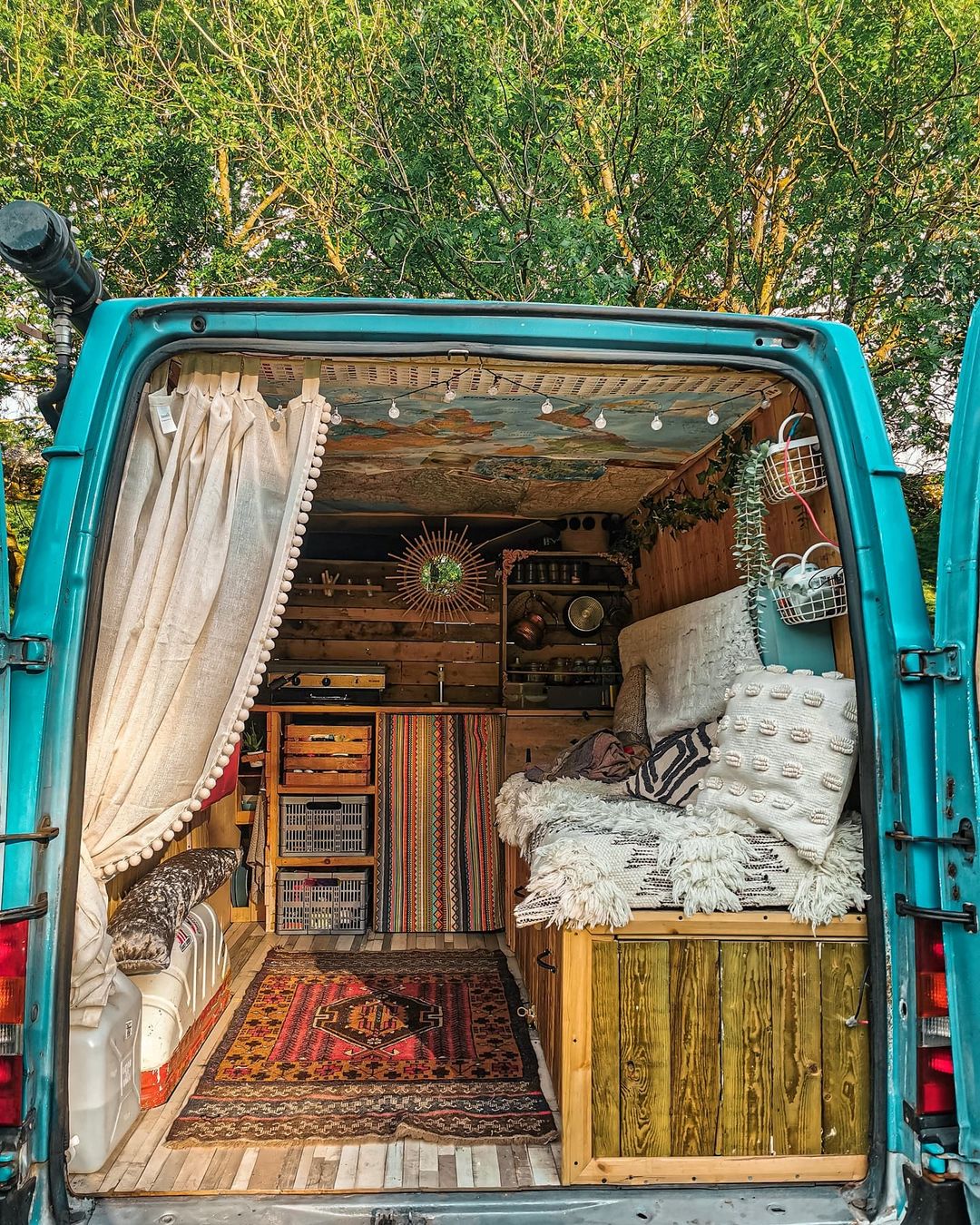 A turquoise van decked out in boho style decorations and accessories.