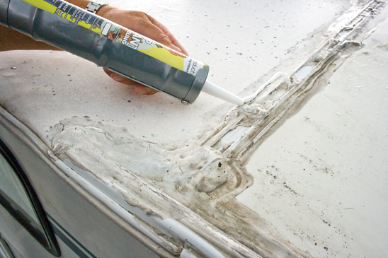 Close up of older RV roof with sealant being applied - best caulk for RV exterior