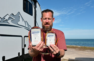 Chris Hinton of Hinton the Trail holds both the new and old softstart ac devices from Network RV.