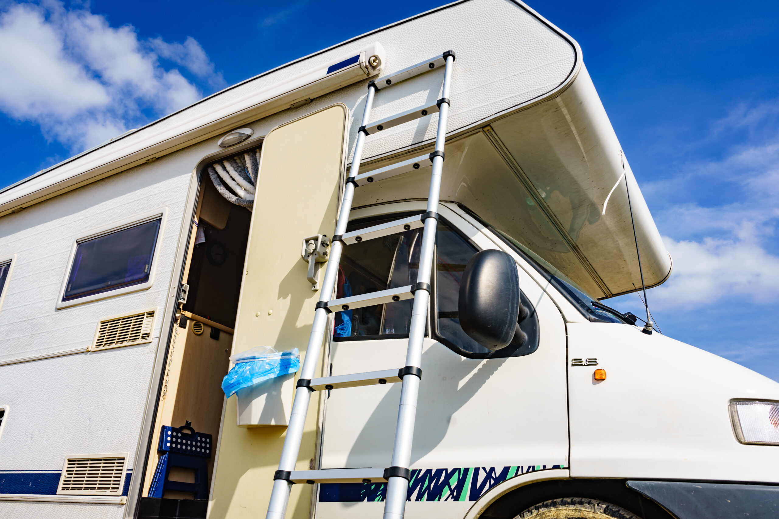 Class C RV with a ladder - feature image for How To Dewinterize An RV