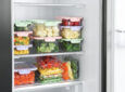 closeup of food in a fridge stacked in containers - feature image for RV fridge storage ideas
