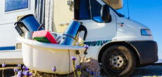 dishes piled up in front of an RV - feature image for how to wash dishes while camping