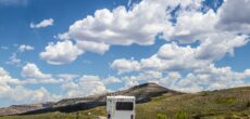 RV driving down highway in Colorado - feature image for How To Insulate Your RV For Summer
