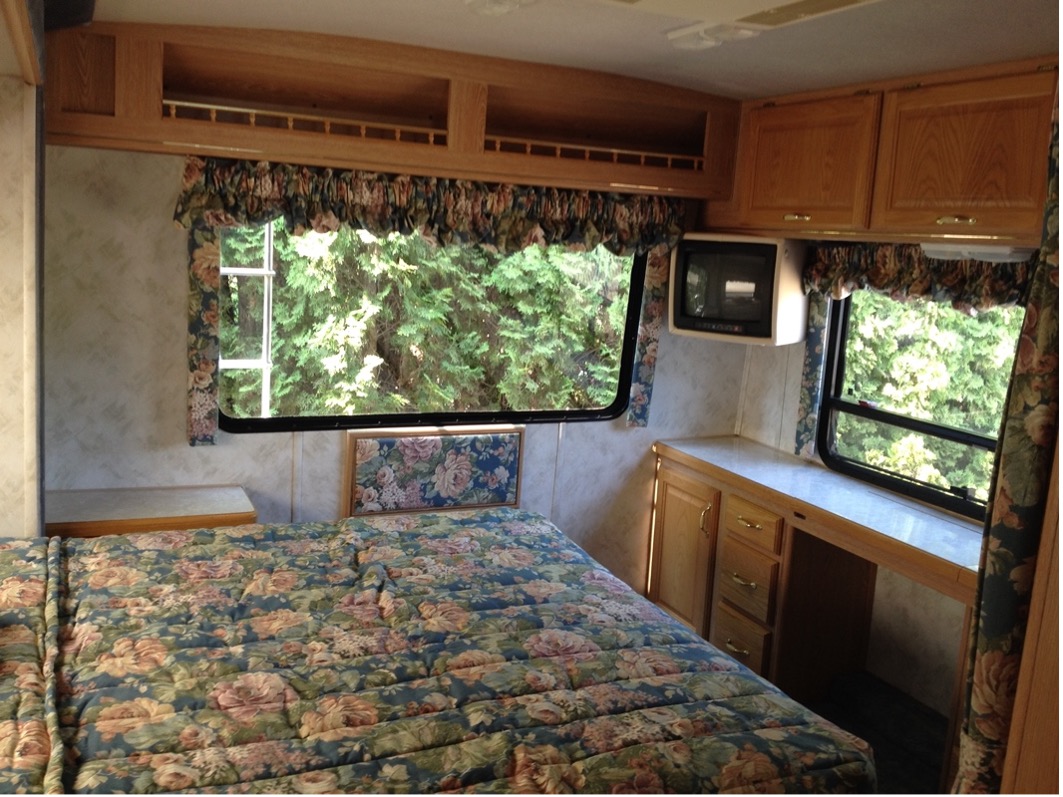 An RV bedroom with windows on three sides