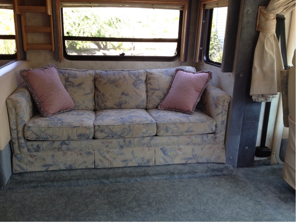 an RV living room with couch and windows and RV window shades