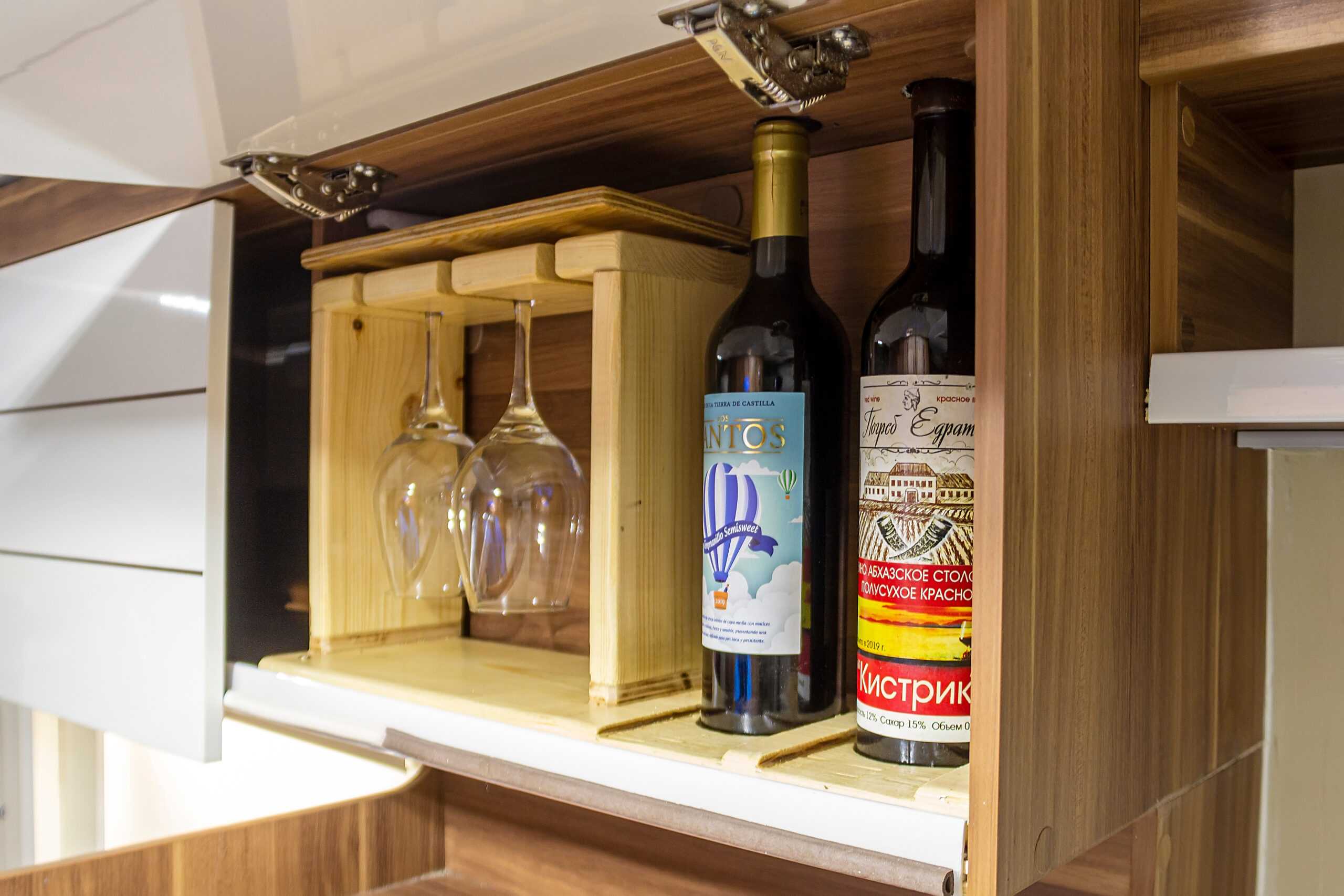 wine bottles and glasses in cabinet, feature image for unexpected uses for everyday items while RVing