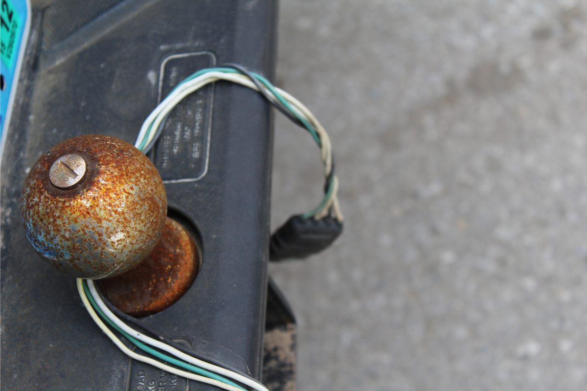 Rusty trailer hitch ball mounted on bumper with trailer wiring connection wrapped around it - how to get a rusted trailer hitch ball off