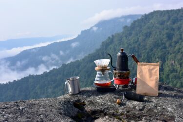 coffee grounds and view of mountains - feature image for can you reuse coffee grounds