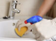 person cleaning with gloves, feature image for bleach alternatives in RVs