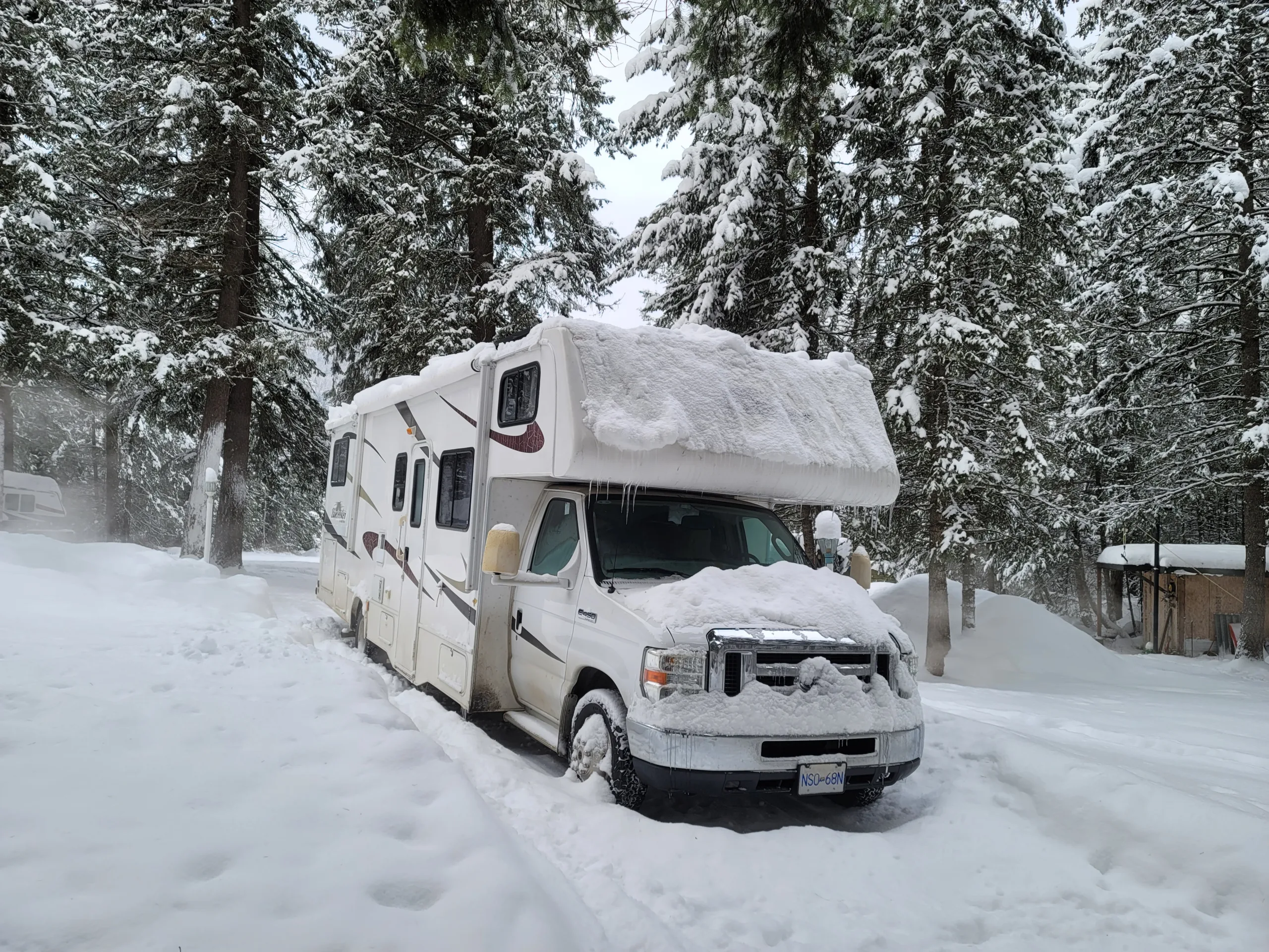 Class C RV covered in snow running an rv refrigerator in cold weather - Photo Courtesy of Snowy Peaks RV