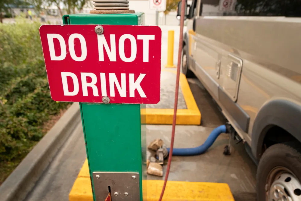 Do Not Drink sign at dump station, feature image for RV gray water tank odors