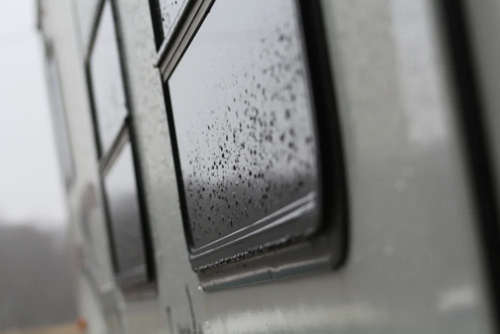Close up of side of RV showing  RV windows with raindrops on them