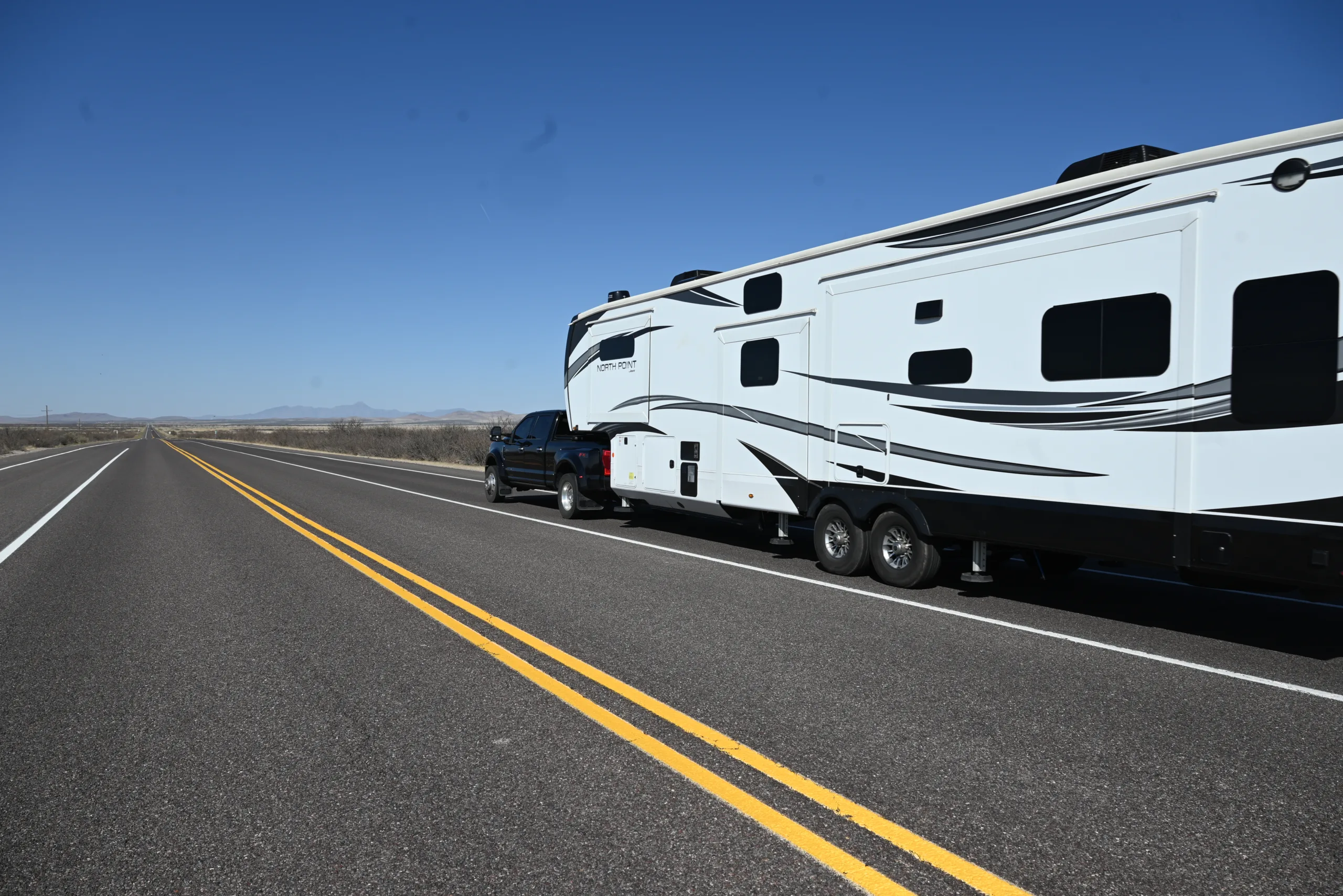a truck pulling a trailer on the side of the road with a trailer attached to the back of it, image for crosswind RV