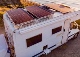 aerial view of RV solar power sytem atop a Class C motorhome parked at a beach
