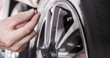 close up showing a man's hand checking RV Recreational Vehicle Tire Pressure.