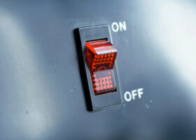 A labeled, red on/off switch much the same as those found on a faceplate inside an RV for the electric water heater