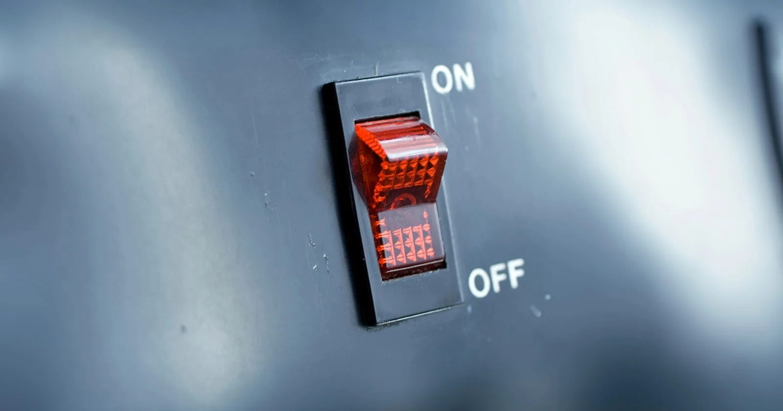 A labeled, red on/off switch much the same as those found on a faceplate inside an RV for the electric water heater
