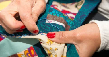 closeup of seamstress sewing a quilt