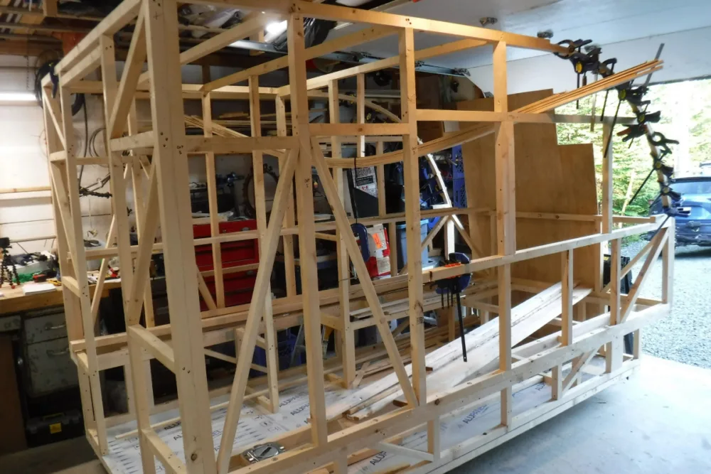 frame of the camper build with over a dozen clamps supporting the curve of one wall.