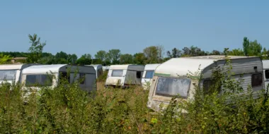 old, abandoned RVs in grassy field ready for RV disposal