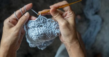 hands using a needle to crochet, a fun craft to enjoy in your RV