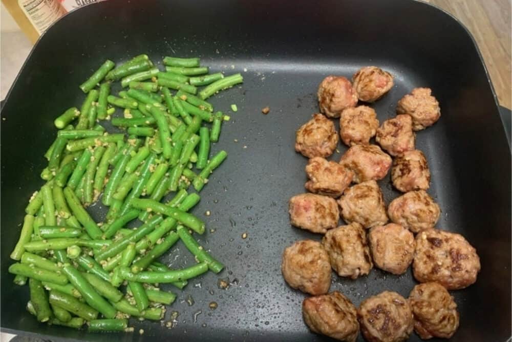 green beans and sausage balls in a skillet