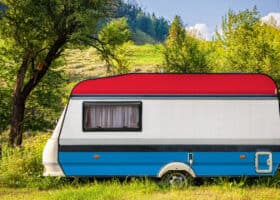 painted travel trailer RV parked in lush setting