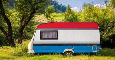 painted travel trailer RV parked in lush setting