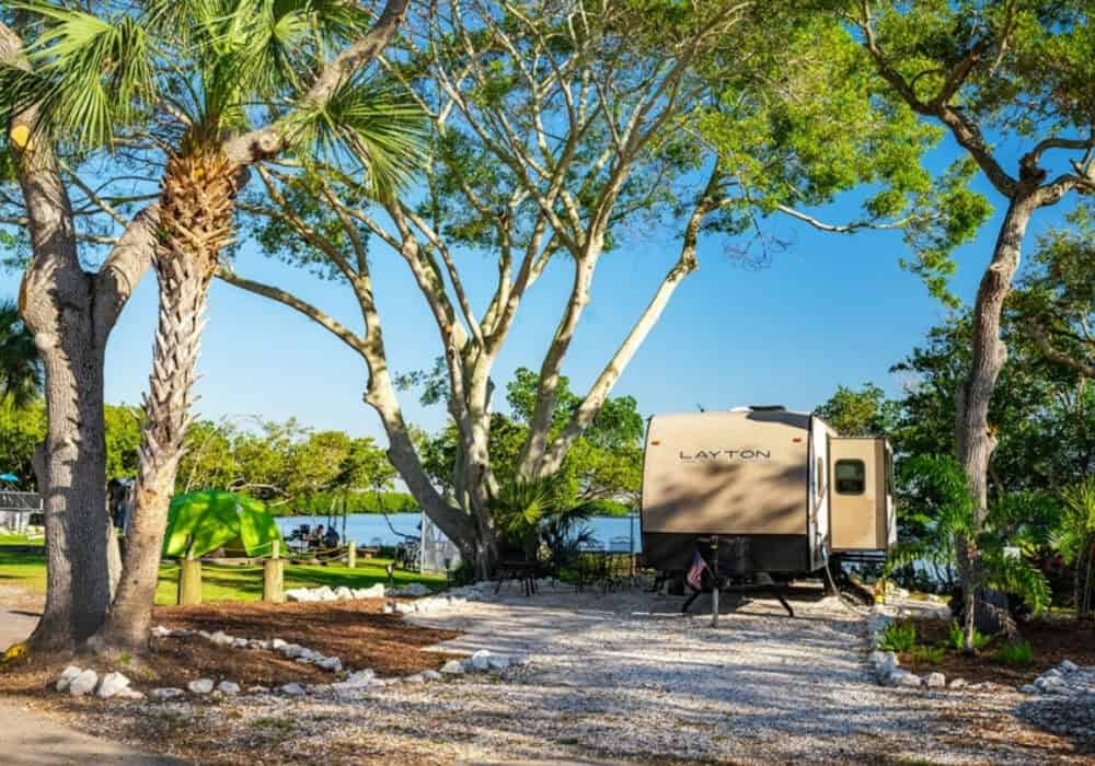 RV in site at KOA campground with water in the background